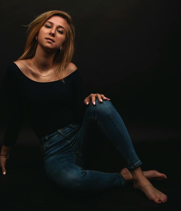 Calm person in a balanced pose against a dark background.